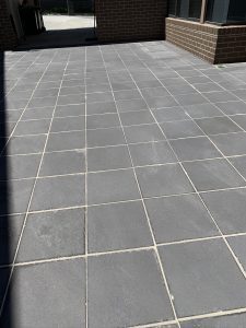Residential garden with stone paving and lawn