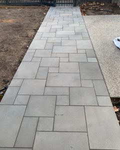 "Residential garden with a paved path and lawn"